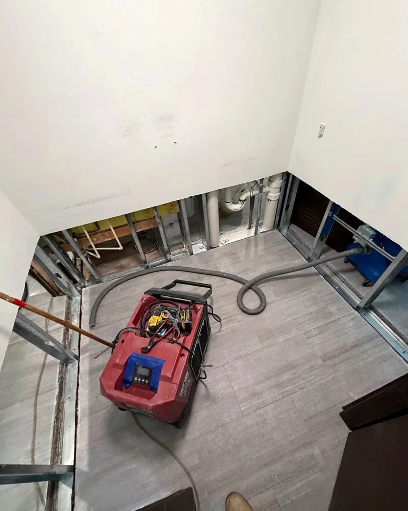Interior demolition at the start of a home renovation, with a dehumidifier running